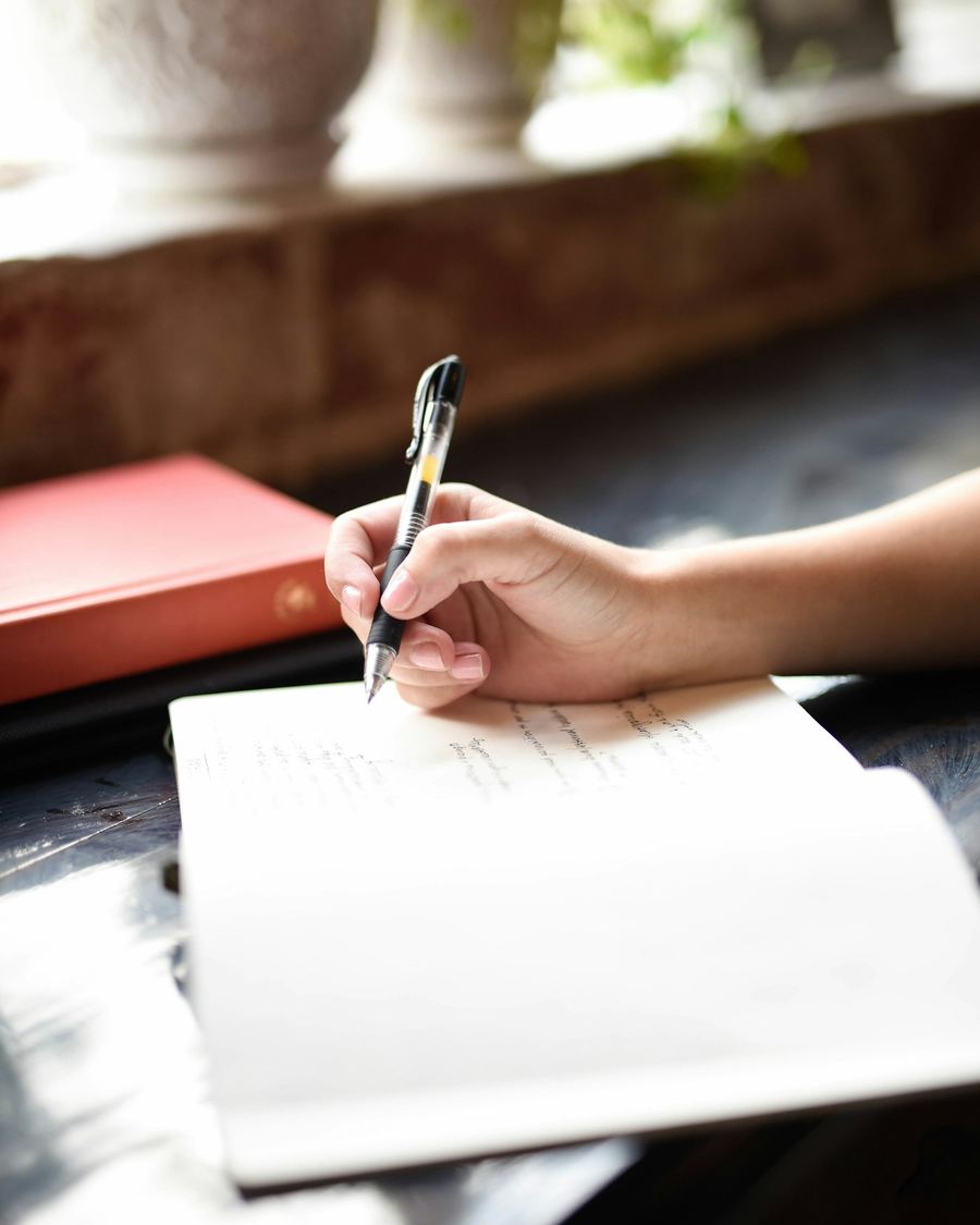 Alguien escribiendo a mano en un cuaderno